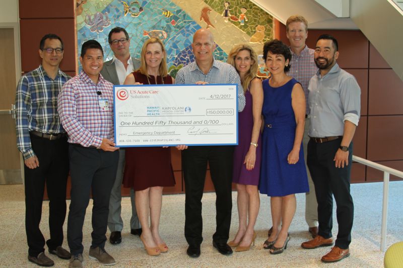 U.S. Acute Care Solutions representatives presenting their check to Kapiolani Medical Center leadership 