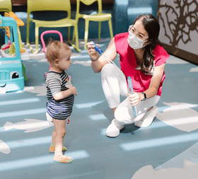 child life specialist with a toddler in the hospital playroom